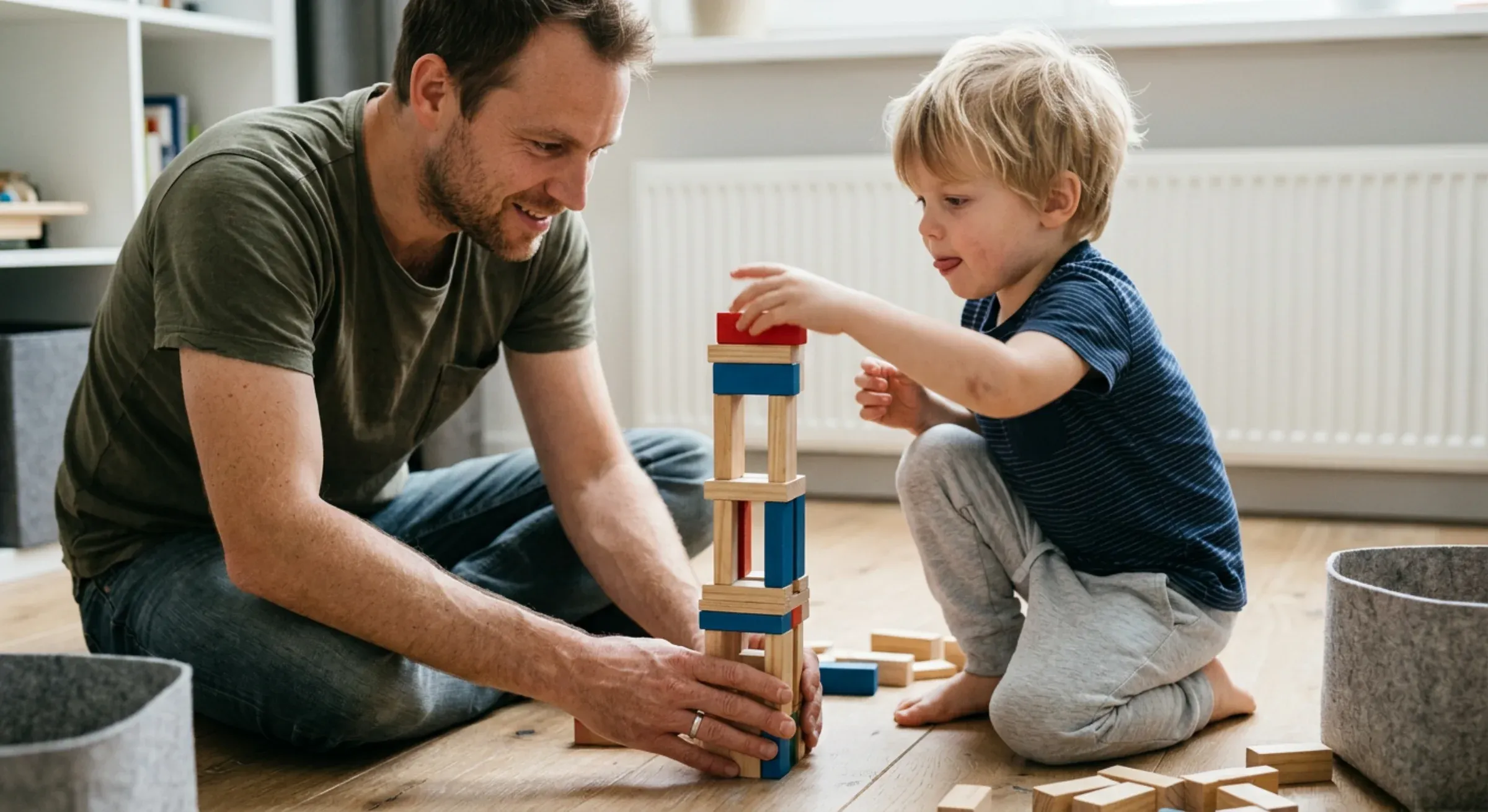 Vader en zoon bouwen samen blokkentoren op de vloer