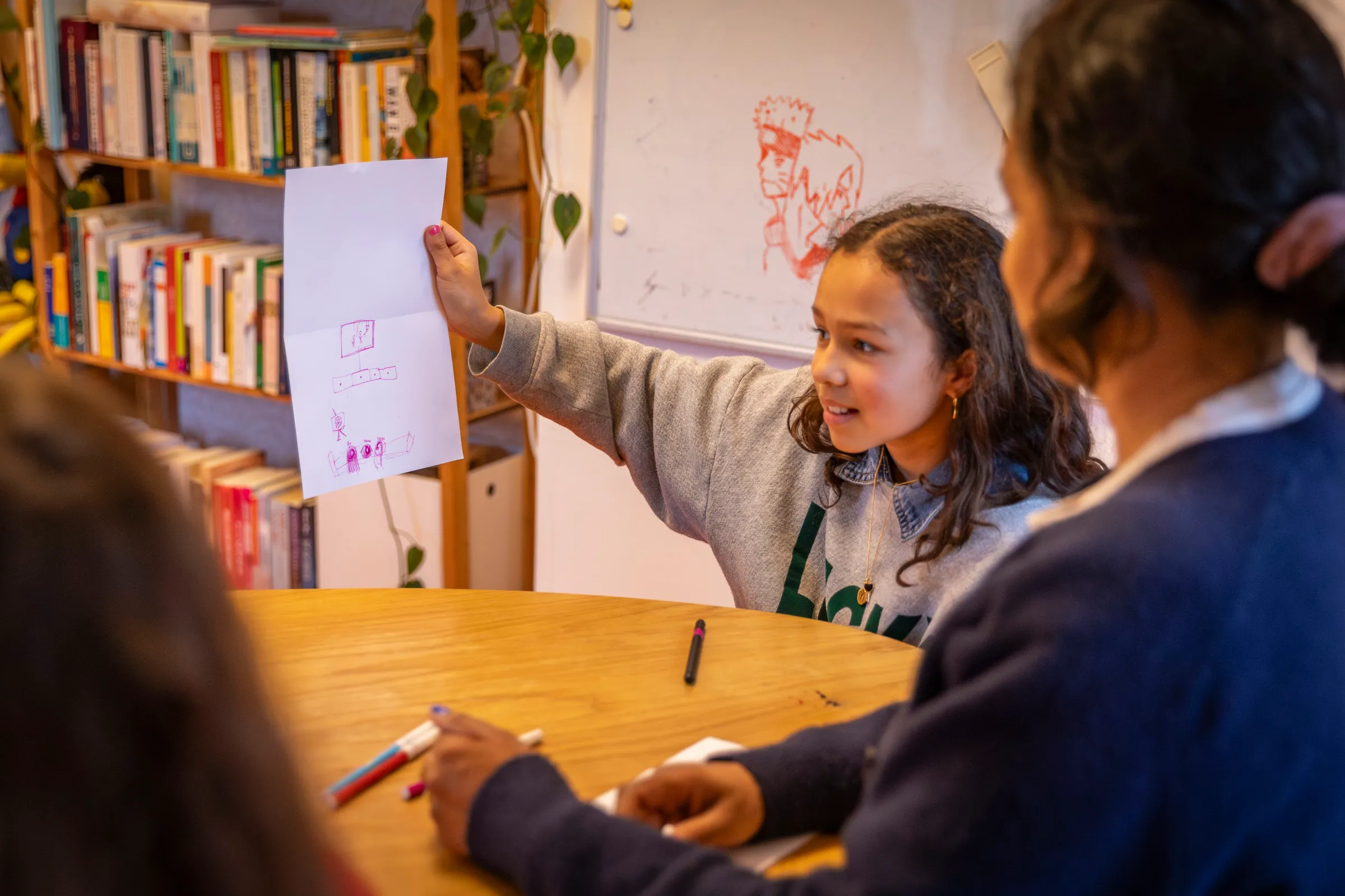 Meisje laat trots haar tekening zien aan therapeut en moeder