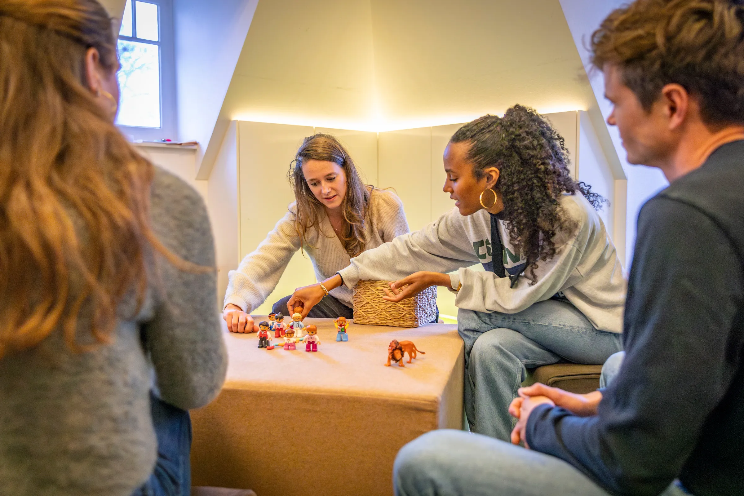 Studenten oefenen met speelfiguurtjes tijdens Familie GGZ opleiding