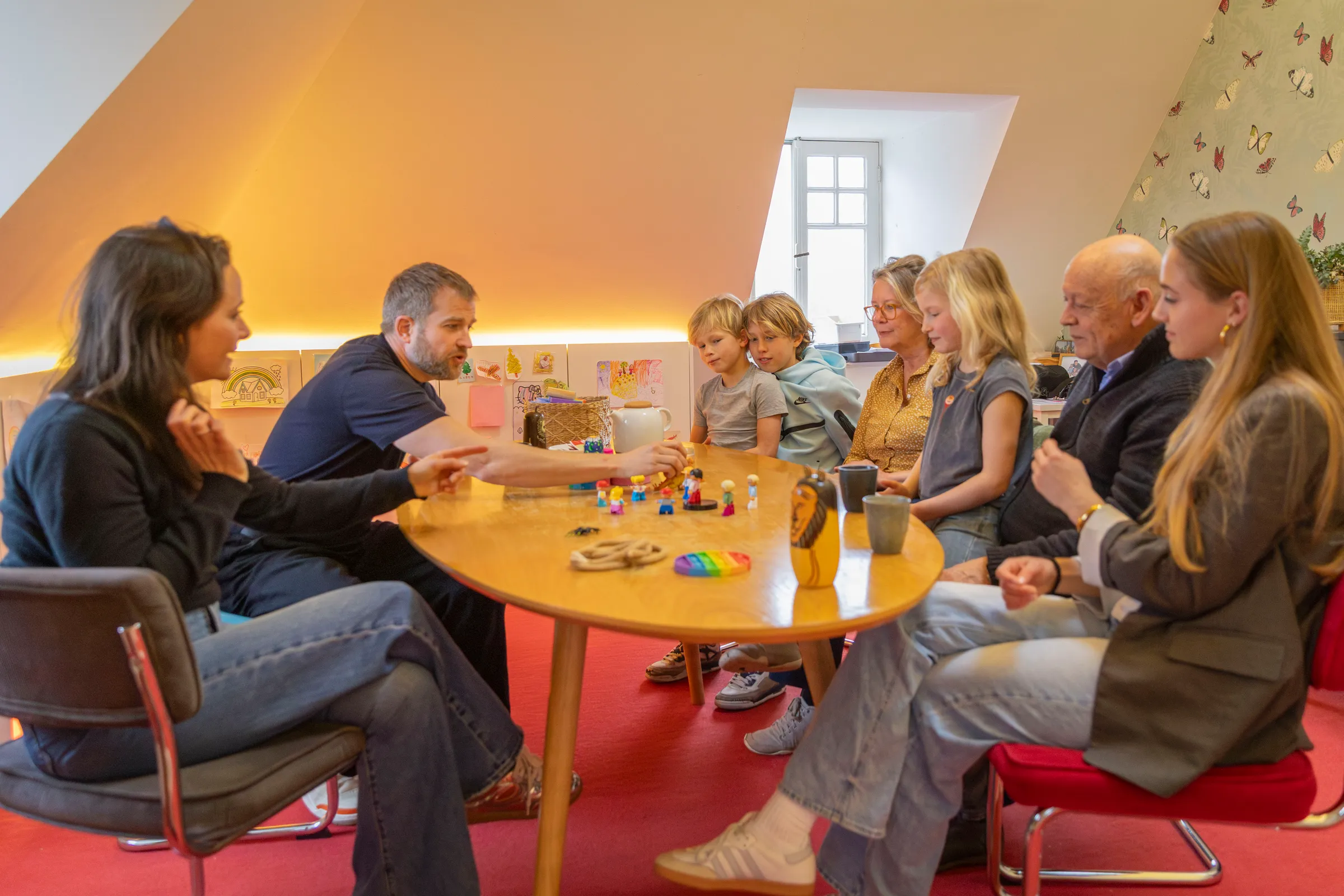 Grootvader met bril leest prentenboek voor aan kleinkind op leren bank